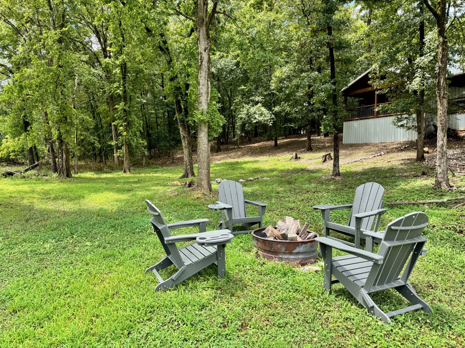 Fire pit lawn at Stay and Play at Pickle Putt Pour, with the cabin and its garage game room in the background