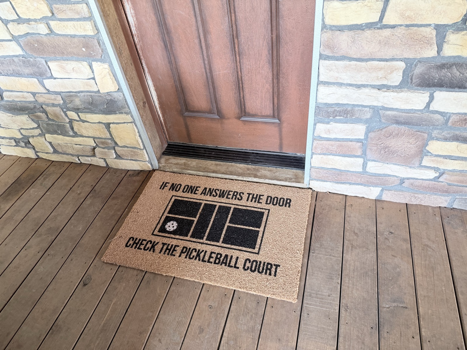 Doormat reading If no one answers the door, check the pickleball court