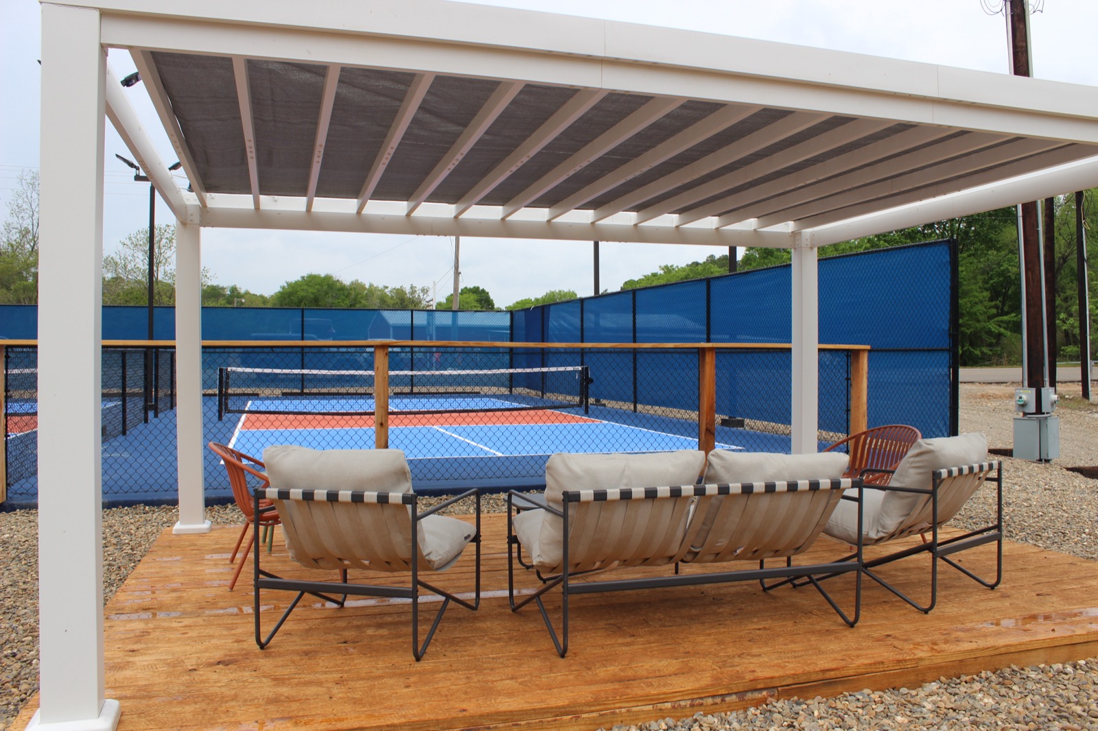 Pickle Putt Pour's covered pergola lounge overlooking a finished pickleball court