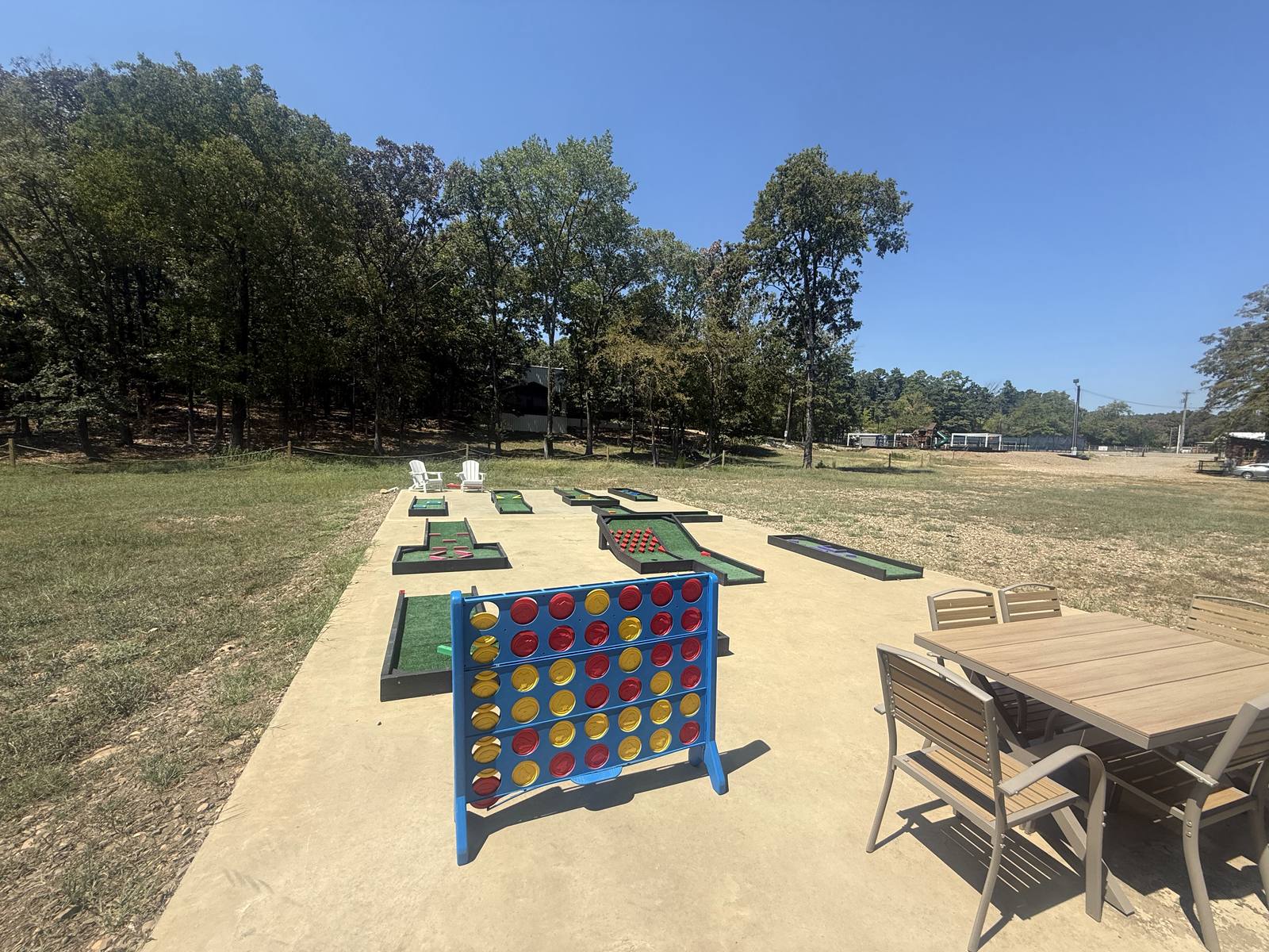The mini golf course at Pickle Putt Pour, with giant Connect Four and shaded seating, an easy walk from the cabin